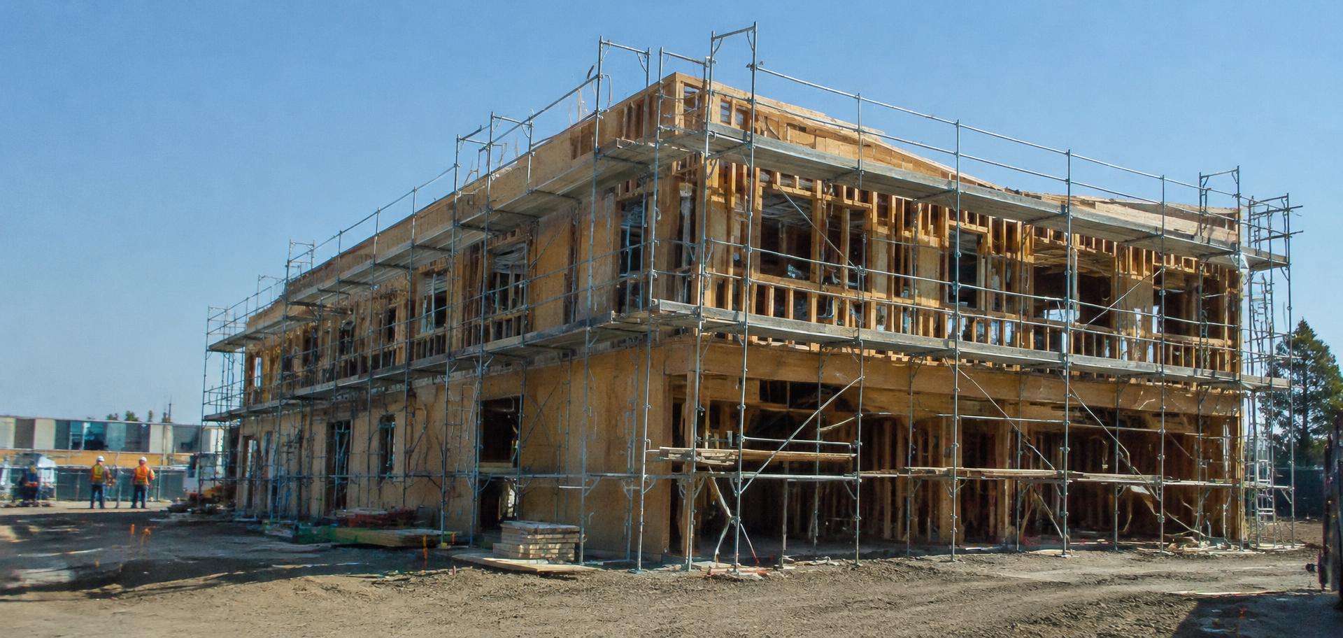 Two-story commercial building framed and wrapped in scaffolding